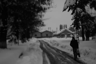 Woman walking on snow covered landscape