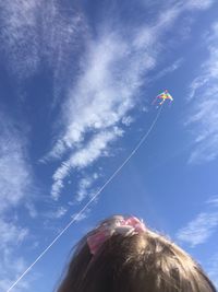 Low angle view of woman flying against sky