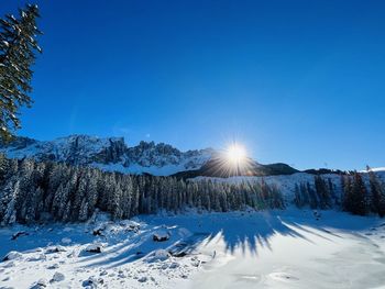 Scenic view of snow covered mountains against clear blue sky