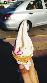 Midsection of woman holding ice cream in car