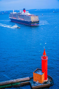 Red ship in sea against blue sky