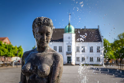 Statue of fountain against building