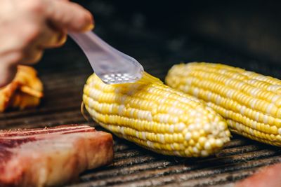 Cropped hand of man holding corn