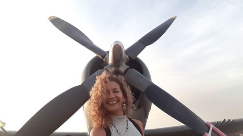 Portrait of smiling young woman against sky