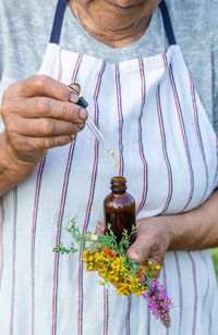 Midsection of woman holding wineglass