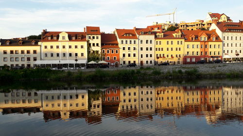 Reflection of buildings in river against sky