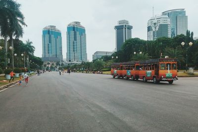 Cars on city street against sky