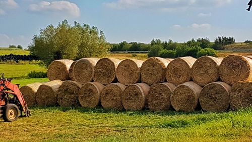 Hay bales on field against sky