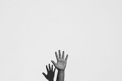 Close-up of hand touching against white background