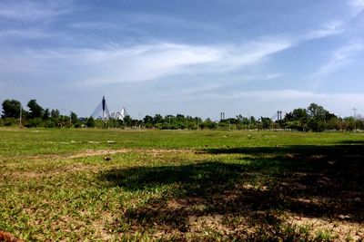 Scenic view of grassy field against sky