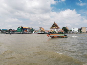 Ship in sea against buildings