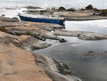 Boat moored on shore by lake