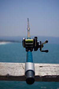 Close-up of coin-operated binoculars by sea against clear sky