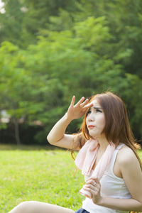 Woman sitting on field at park