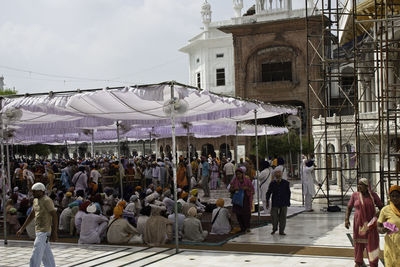 Group of people in market against buildings in city