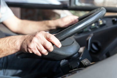 Close-up of man holding cigarette in car