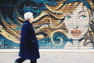 Woman standing by wall