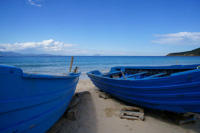 Boats moored on sea shore against sky