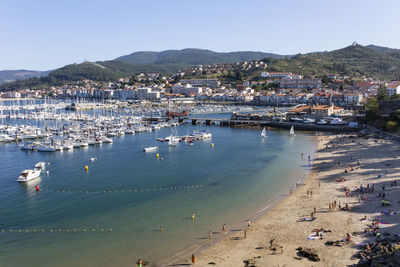 Aerial view of townscape by sea against clear sky