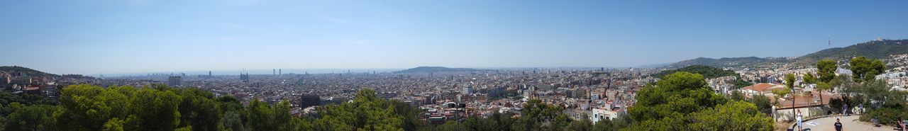 Panoramic view of trees and buildings against sky