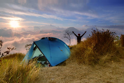 Tent on field against sky during sunset