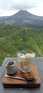 Coffee cup on table against mountains