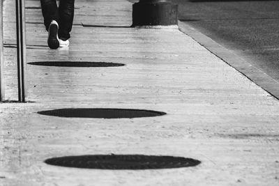 Low section of man walking on walkway