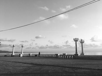 Street light by sea against sky