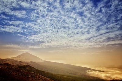 Scenic view of mountains against cloudy sky