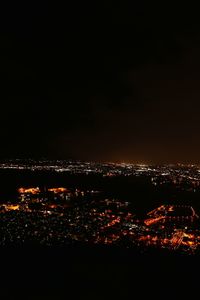 Illuminated cityscape against sky at night