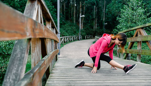 Woman exercising on footbridge at park