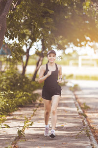 Portrait of a smiling young woman on footpath