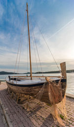 Sailboats moored on sea against sky