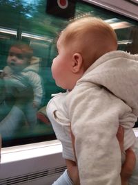 High angle view of boy looking through train window