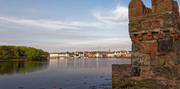 View of old building by river against sky