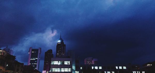 Low angle view of illuminated buildings against sky at night