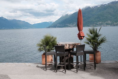 Lifeguard chair by sea against mountains