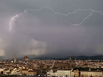 Panoramic view of lightning over city against sky