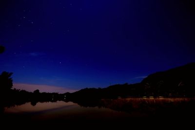 Scenic view of lake against sky at night