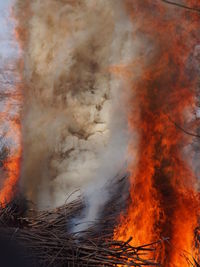 Low angle view of bonfire against orange sky