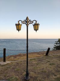 View of street light on beach against clear sky