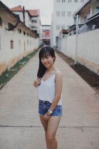 Young woman standing outdoors against building