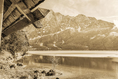 Scenic view of lake by mountain against sky