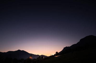 Scenic view of silhouette mountains against clear sky during sunset