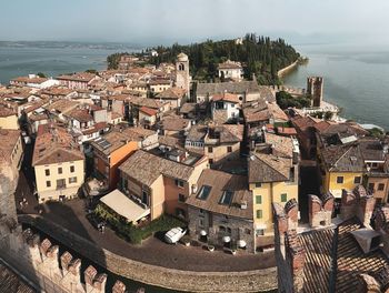 High angle view of townscape by sea against sky