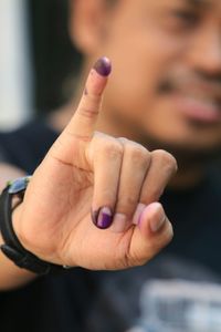 Close-up portrait of man showing pinky finger