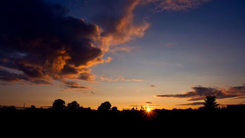 Silhouette trees against sky during sunset