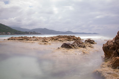 Rocks on beach against sky