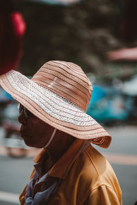 Side view of woman wearing hat standing outdoors