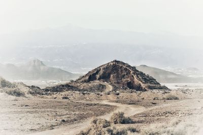 Scenic view of arid landscape against sky